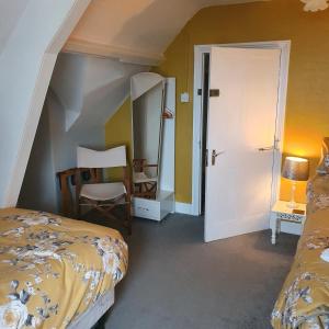 a bedroom with a bed and a desk and a chair at Pendyffryn Manor Bed & Breakfast in Little Haven