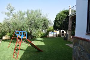 a playground with a slide in a yard at Casa Crisal in Arriate