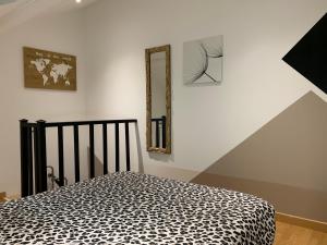 a bedroom with a bed with a leopard print blanket at Petite maison atypique cocooning in Raon-lʼÉtape