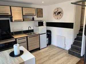 a small kitchen with a sink and a microwave at Petite maison atypique cocooning in Raon-lʼÉtape