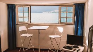 a room with a table and two chairs and a window at Casa Zoe in Lezzeno