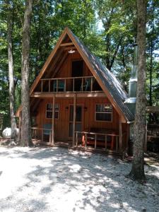 une cabine dans les bois avec un toit en gambrel dans l'établissement Tranquil Oaks Cabin, à Wellington