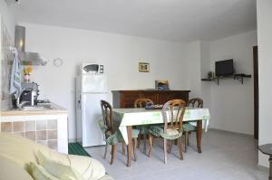 cocina con mesa y sillas en una habitación en Jajo Apartments, en Castelsardo
