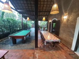 a room with a pool table and a brick wall at Casa na praia de Itamambuca na cidade de Ubatuba in Ubatuba