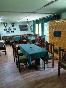 una sala da pranzo con tavolo e sedie verdi di Mátrai Vadászház 2 a Mátraterenye