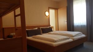 two beds in a hotel room with a window at Hotel und Gasthof Ritter St. Georg in Erlangen