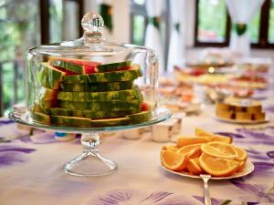 a cake in a glass case on a table with fruit at Zamek Otmuchów in Otmuchów