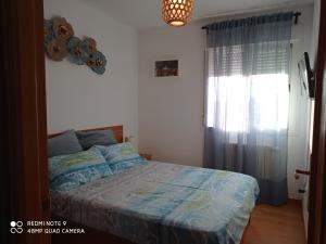 ein Schlafzimmer mit einem Bett mit blauer Decke und einem Fenster in der Unterkunft Deep Blue Inn in Torrecaballeros