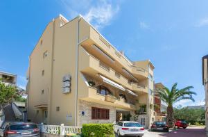 a building with cars parked in front of it at Apartments Barba in Tučepi