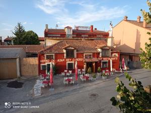 ein rotes Gebäude mit Tischen und Stühlen davor in der Unterkunft Deep Blue Inn in Torrecaballeros