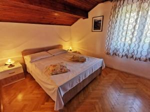 a bedroom with a bed with two pillows on it at Apartments Sokolic in Nerezine