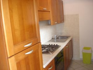 a small kitchen with wooden cabinets and a sink at La Corte in Pisa