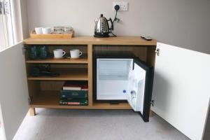 a small cabinet with a refrigerator in a room at The Snug at the Ski Lodge, Aviemore in Aviemore