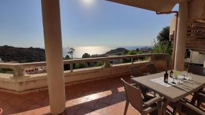 einen Balkon mit einem Tisch und Stühlen sowie Meerblick in der Unterkunft Appartamento 3 in Nebida