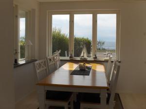 a dining room table and chairs with a view of the ocean at Strandvillan, Öland - fantastiskt läge nära havet! in Löttorp