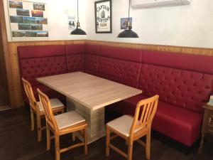 einen Tisch und Stühle in einem Restaurant mit einer roten Kabine in der Unterkunft Ferienhaus-Elisabeth Bungalow-Tom Bungalow-Peter in Reinhardtsdorf