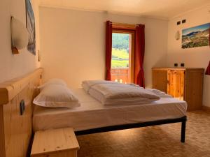 sypialnia z dużym łóżkiem i oknem w obiekcie Casa Susanna w Livigno