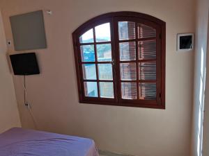 a bedroom with a window and a bed in it at Casa a 3 minutos da praia in Saquarema