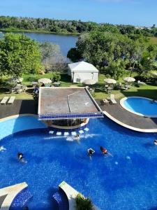 a large pool with people in the water at a resort at Paraíso das Águas in Guarajuba