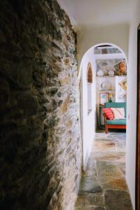 a hallway in a house with a stone wall at Casa das Videiras in Monsaraz