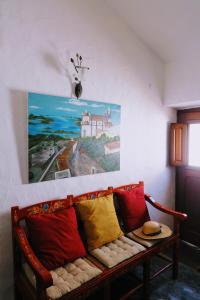 a couch with colorful pillows sitting under a painting at Casa das Videiras in Monsaraz