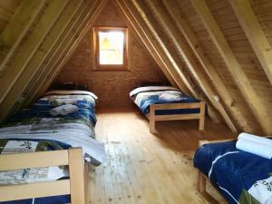 a room with two beds in a attic at Camp Volujak in Volujak