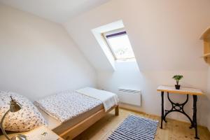 Habitación pequeña con cama y ventana en Bakony-Cinca Vendégház, en Szentgál