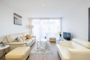 a living room with white couches and a tv at Silver Apartment Kew Bridge London in Kew Bridge