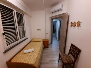 - une chambre avec un lit, une chaise et une fenêtre dans l'établissement GUEST HOME, à Ischia