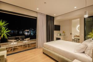 ein Schlafzimmer mit Bett und Balkon mit Aussicht in der Unterkunft Rea Boutique Hotel in Himarë + 37 Fotos