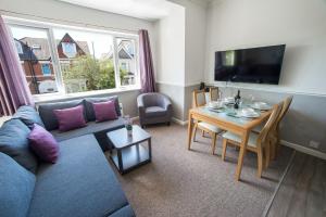 a living room with a couch and a table at Sea Road Apartments in Bournemouth