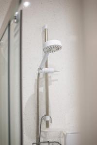 a shower head in a bathroom next to a sink at Sea Road Apartments in Bournemouth +46 photos