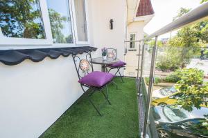 a small balcony with purple chairs and a table at Sea Road Apartments in Bournemouth