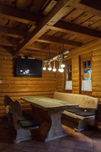 a dining room with a table and a tv at Golomán Gerendaház és Vendégház in Ispánk