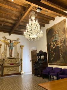 une chambre avec un lustre, un tableau et un piano dans l'établissement Hotel Boutique Posada XVII, à Puebla