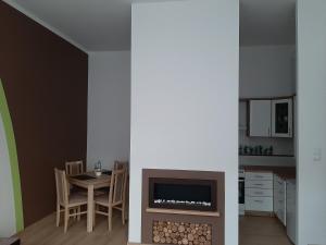 a living room with a table and a fireplace at Apartament nad Jeziorem Olecko in Olecko