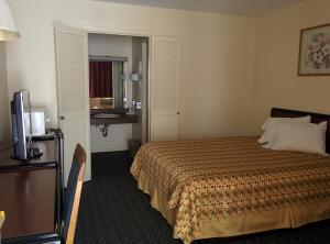 a hotel room with a bed and a television at Economy Inn Toledo-Perrysburg in Perrysburg