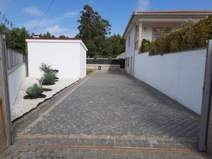 a driveway leading to a house with white fences at Alojamento Rio Neiva in Boticas