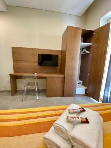 Habitación con cama, TV y escritorio. en B&B Don Savè, en Marina di Schiavonea