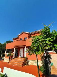 a orange house with a tree in front of it at Petra Apartment in Rab