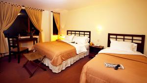 Un pat sau paturi într-o cameră la Hotel San Sebastián Loja