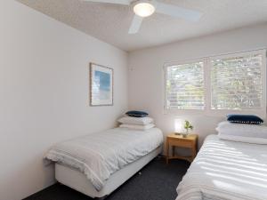 um quarto com duas camas e uma janela em Intrepid 1 3 Intrepid Close Amazing views of Shoal Bay only 100m from the Beach em Shoal Bay