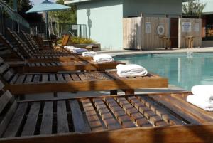a pool with several lounge chairs next to a swimming pool at Wyndham Garden Hotel Austin in Austin