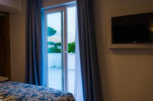 a bedroom with a sliding glass door to a balcony at Piccolo Hotel in Terracina