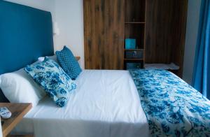 una camera da letto con letto e lenzuola e cuscini blu e bianchi di Piccolo Hotel a Terracina