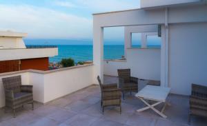 balcón con mesa, sillas y vistas al océano en Piccolo Hotel, en Terracina