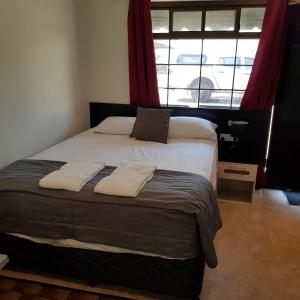 
a bedroom with a bed and a window at Motel Lodge in Rockhampton
