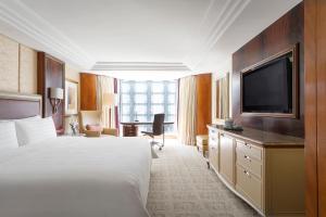 a hotel room with two beds and a television at Kowloon Shangri-La, Hong Kong in Hong Kong