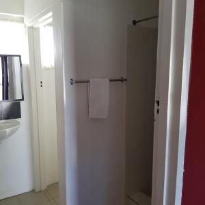 a bathroom with a shower and a white towel at Motel Lodge in Rockhampton