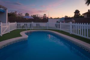 une clôture blanche et une piscine à côté d'une clôture dans l'établissement Villa Julia, à Riumar